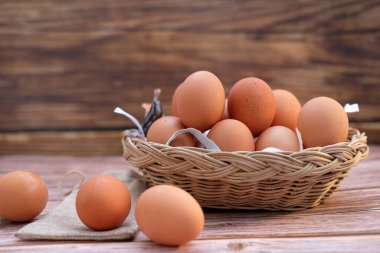 Tahta arka planda sepetteki tavuk yumurtaları ve metin için boşluk