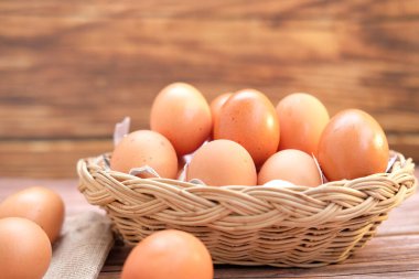 Tahta arka planda sepetteki tavuk yumurtaları ve metin için boşluk