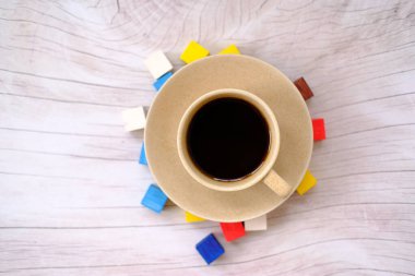 Kahve fincanı ve kahve çekirdekleri masa arkasında ve metin için boşluk