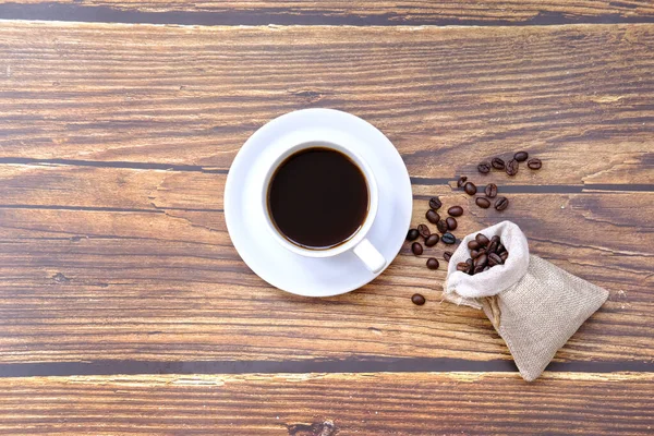 Kahve Fincanı Kahve Çekirdekleri Eski Ahşap Masa Arkasında — Stok fotoğraf