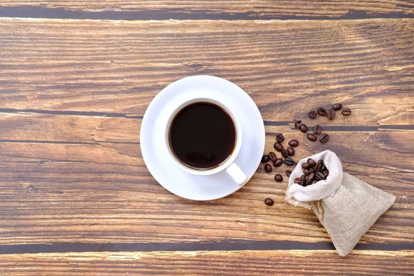 Kaffeetasse Und Kaffeebohnen Auf Altem Holztischhintergrund — Stockfoto