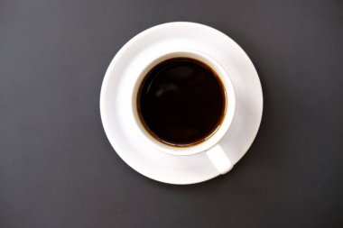 Arka planda bir fincan kahve ve latte sanatı