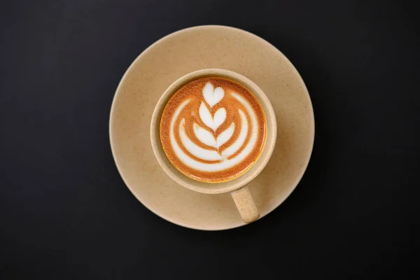 cup of coffee and latte art on table background