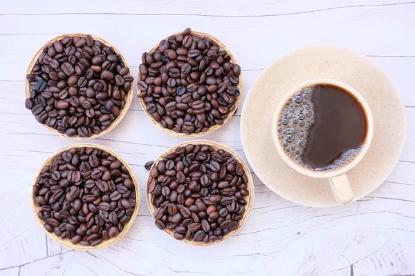 コーヒー豆と木製のテーブルの上にカップ — ストック写真