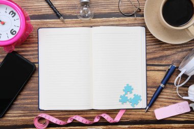 Telefon, okuma gözlüğü ve kalemle defteri aç 