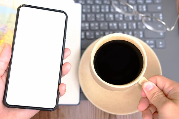 Üst düzey bir iş adamı akıllı telefon kullanıyor ve masada çalışıyor.
