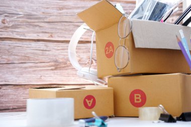 Merkez ofisteki müşterilere paket hazırlamak, karton kutuları masaya yerleştirmek. Çevrimiçi satış, e-ticaret kavramı