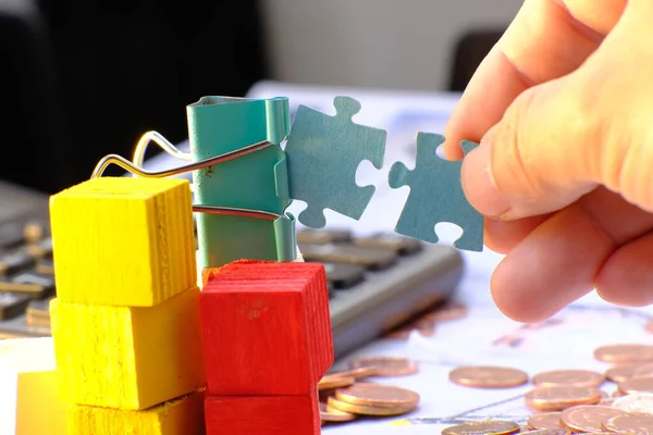 man\'s hand putting puzzle pieces together