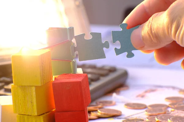 man\'s hand putting puzzle pieces together