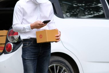 Paketli teslimatçı, arabanın yanında karton kutular.