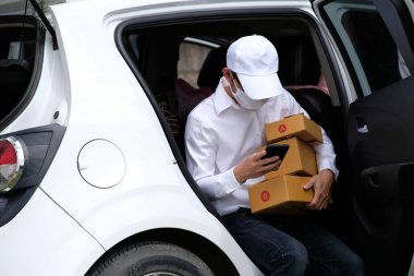 Paketli teslimatçı, arabanın yanında karton kutular.