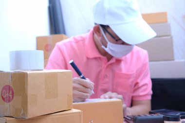 İş adamı ev konsepti ve ücretsiz teslimat için çok çalışıyor. Çevrimiçi alışveriş ve ekspres teslimat, koruyucu maske takan alışveriş kutusu satıcısı. 