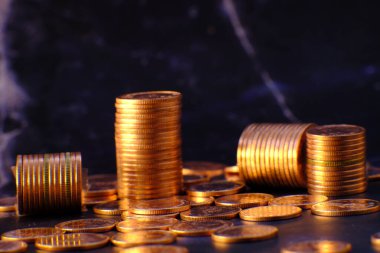 Siyah arka planda altın para yığını ve reklam paraları finans ve bankacılık, artan altın madeni para sütunları masa üzerinde