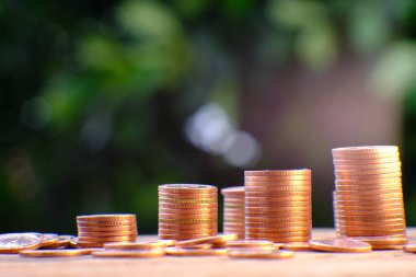 Siyah arka planda altın para yığını ve reklam paraları finans ve bankacılık, artan altın madeni para sütunları masa üzerinde