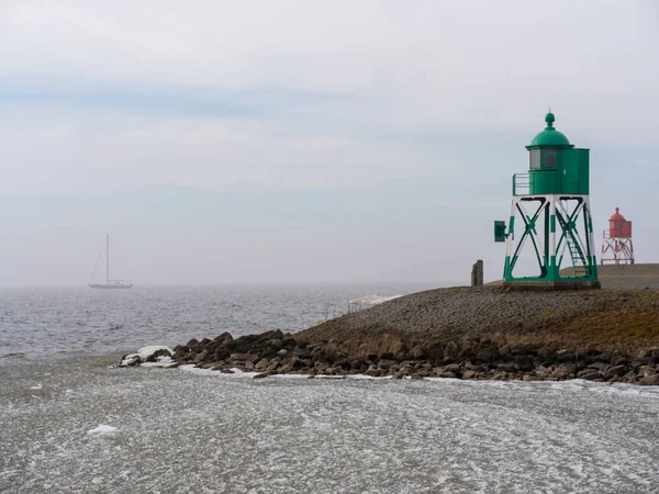Port lights of Stavoren in the Dutch province of Friesland in winter conditions. The IJsselmeer has been partially frozen, the remains are still clearly visible.