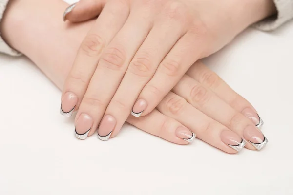 Mãos com unhas bem cuidadas cobertas com esmalte rosa sobre fundo de pele — Fotografia de Stock