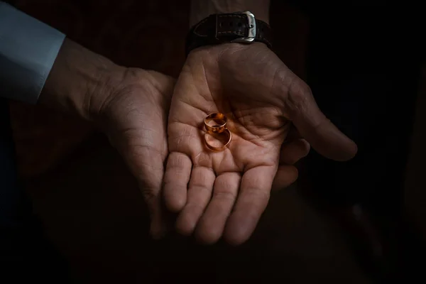 Novio celebración de anillos de boda en la palma, el novio en un traje azul, novio celebración de anillos de boda, los novios de la mano sosteniendo un anillo, anillo de boda en la mano del novio — Foto de Stock