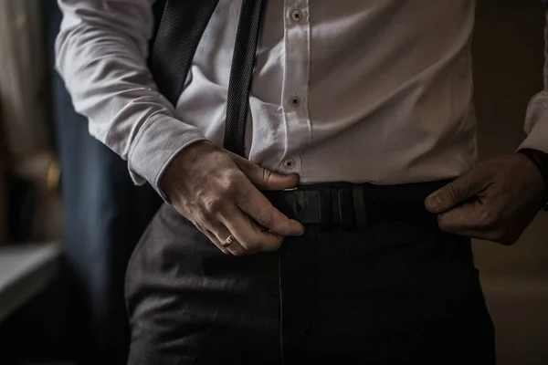 Groom in black tuxedo and bowtie correct his buttons on white shirt. Wedding. Details Stock Photo