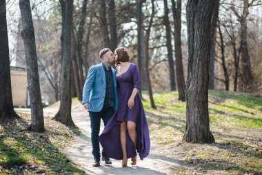 Parkta akşam ışığında mutlu bir aile. Güneşin ışıkları. Anne, baba ve bebek gün batımında mutlu yürüyüşe. Mutlu bir ailenin kavramı. Ebeveynler babys ellerini tutun.