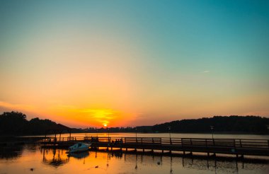 Karadeniz 'de gün batımında muhteşem bir manzara ve üzerinde muhteşem bir güneş ışığı olan turuncu gökyüzü arka plan olarak sakin dalgaların üzerinde. Sahilde muhteşem bir yaz gün batımı manzarası. Rus doğası, Soçi.