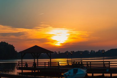Karadeniz 'de gün batımında muhteşem bir manzara ve üzerinde muhteşem bir güneş ışığı olan turuncu gökyüzü arka plan olarak sakin dalgaların üzerinde. Sahilde muhteşem bir yaz gün batımı manzarası. Rus doğası, Soçi.