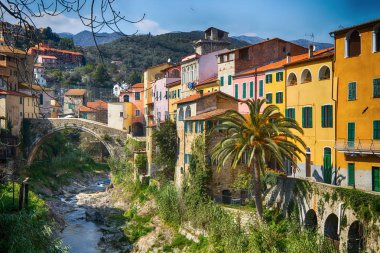Colorful houses in a small village with stone bridge at Dolcedo Imperia Liguria Italy clipart