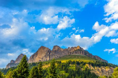 Rosengarten grup çayırlar ve çam ağaçları altında mavi bir bulutlu gökyüzü, Dolomites, İtalya ile (Rosengarten) Dağları'nın görünümü