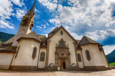 Güzel dağ kilise bulutlar ile güneşli mavi gökyüzü altında / Moena / Trentino / Fassa Vadisi / İtalya