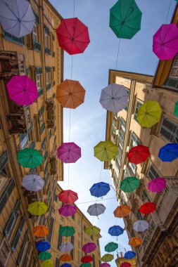 Cenova, İtalya, 16 Nisan 2018 - Cenova, İtalya'nın merkezi Galleria Mazzini yukarıda gökyüzünde çok renkli şemsiyeler.