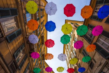 Cenova, İtalya'nın merkezi sokaklarda yukarıda gökyüzünde çok renkli şemsiyeler.