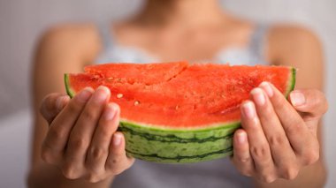 Dilim karpuz ile arka plan bulanık holding eller