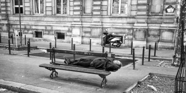 Paris, Fransa, 7 Eylül 2018 - Paris, Fransa, sokaklarında ahşap bir bankta uyuyan bir adam.
