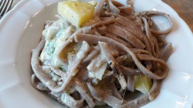 Yakın çekim pizzoccheri , İtalyanca ilk ders tabağı. Valtellina pizzoccheri karabuğday unu ile hazırlanan makarna çeşitli ve peynir, tereyağı, savoy lahana ve haşlanmış patates ile seasioned vardır