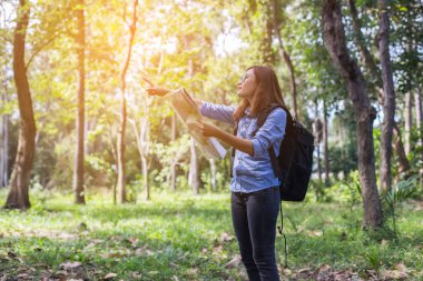 Kadınlar uzun yürüyüşe çıkan kimse sırt çantası ile vahşi alanda yön bulmak için harita denetler