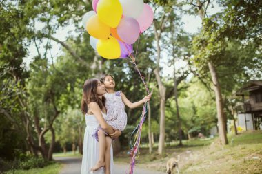 Doğa ve güneş ışığı, keyfi aile kızıyla taşıyan anne.