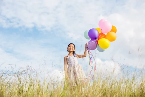 Carina Bambina Che Tiene Palloncini Colorati Nel Prato Contro Cielo — Foto Stock