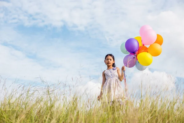 Ładna Dziewczynka Gospodarstwa Kolorowe Balony Łące Przeciw Błękitne Niebo Chmury — Zdjęcie stockowe