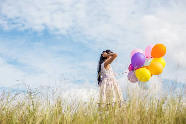 Carina Bambina Che Tiene Palloncini Colorati Nel Prato Contro Cielo — Foto Stock