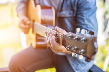 Genç hipster adam onun tatile rahatlatıcı için gitar çalmak zevk ile doğal ve taze hava.