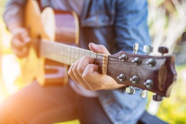Genç hipster adam onun tatile rahatlatıcı için gitar çalmak zevk ile doğal ve taze hava.