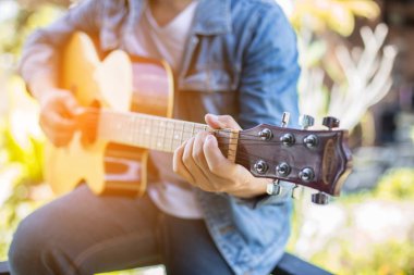 Genç hipster adam onun tatile rahatlatıcı için gitar çalmak zevk ile doğal ve taze hava.