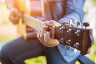 Genç hipster adam onun tatile rahatlatıcı için gitar çalmak zevk ile doğal ve taze hava.