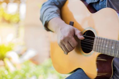 Genç hipster adam onun tatile rahatlatıcı için gitar çalmak zevk ile doğal ve taze hava.