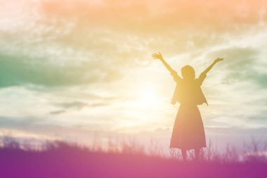 Güzel bir arka plan için dua eden bir kadın silueti.