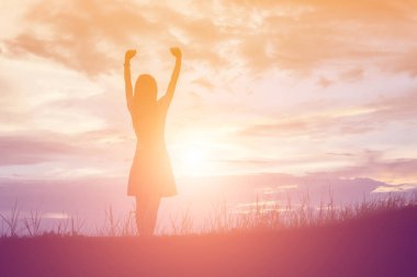 Güzel bir arka plan için dua eden bir kadın silueti.