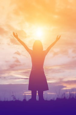 Güzel bir arka plan için dua eden bir kadın silueti.