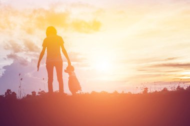 gökyüzü günbatımı bir yaz gününde önünde bir sarılmak için onun sevgi dolu silah siluet bir mutlu genç kız çocuğu anne.