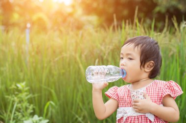 Tatlı küçük kız su içiyor.