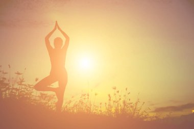 Güzel bir arka plan için dua eden bir kadın silueti.