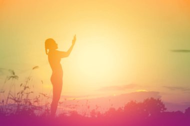 Güzel bir arka plan için dua eden bir kadın silueti.